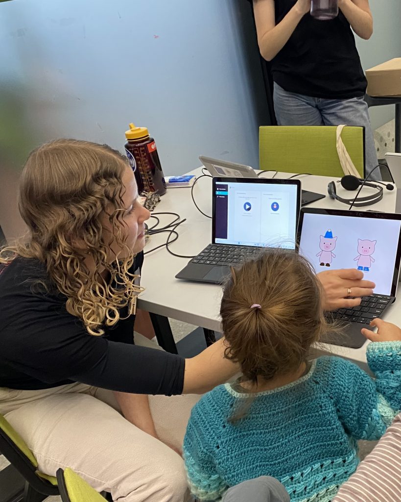 An adult is showing a kid a game on a tablet. 